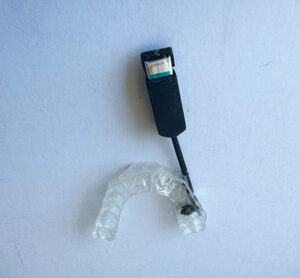 Image of an early Zerene prototype by founder Arash Sabet. It features a mouthguard with a device attached to to it.